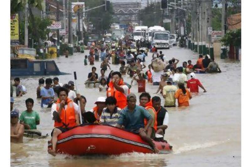 Rescuers manoeuvre a rubber boat carrying villagers as others wade through floodwaters after Typhoon Nalgae hit the Philippines, dumping heavy rain which increased flood levels, in Calumpit, north of Manila. Cheryl Ravelo / Reuters