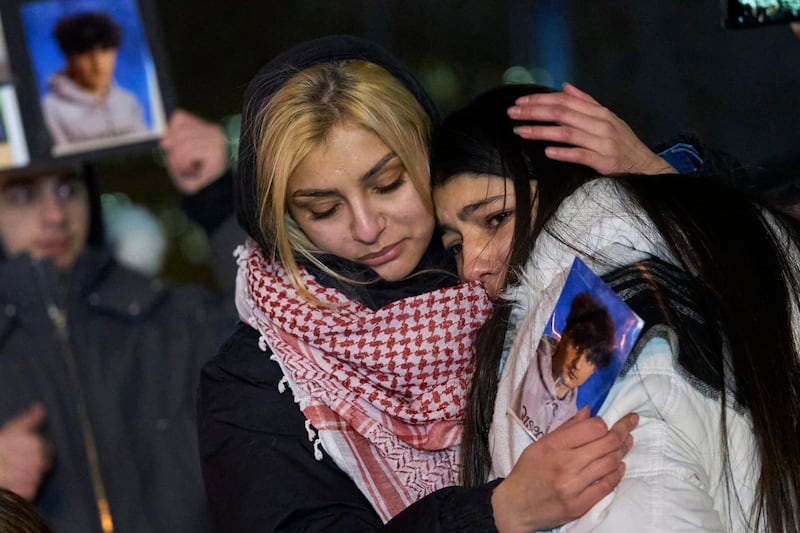 Mourners console each other during a vigil for the victims of Ukrainian Airlines flight 752 which crashed in Iran during a vigil at Mel Lastman Square in Toronto, Ontario on January 9, 2020. - A Ukrainian airliner crashed shortly after take-off from Tehran on January 8 killing all 176 people on board, in a disaster striking a region rattled by heightened military tensions. (Photo by Geoff Robins / AFP)
