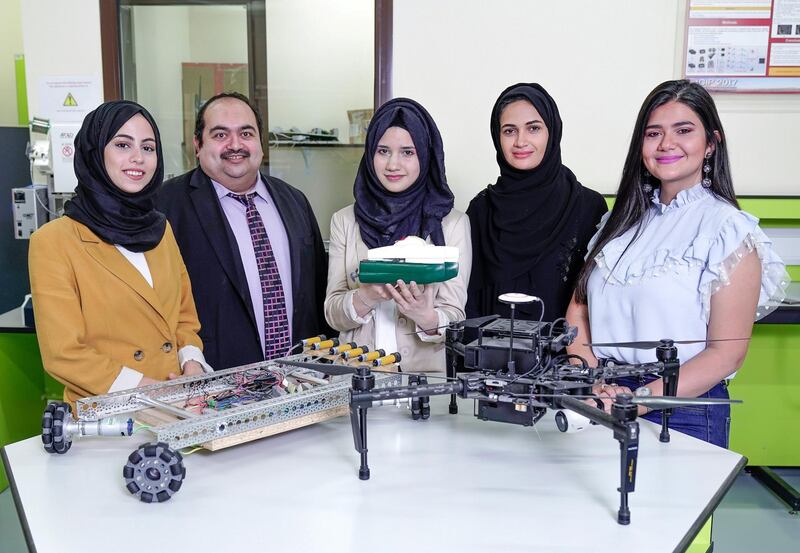 Abu Dhabi, United Arab Emirates, August 4, 2019.  A robot developed at Abu Dhabi University that can collect litter from the sea. The robot communicates with a drone that photographs the sea and uses artificial intelligence to determine the best way to get to rubbish to collect it. --  (L-R)   Tasnim AlAs'ad, Dr. Mohammed Ghazal, Dana Almanla, Eiman Alnaqbi, Leen AlAssadi.
 Victor Besa/The National
Section:  NA
Reporter:  Sophie Prideaux