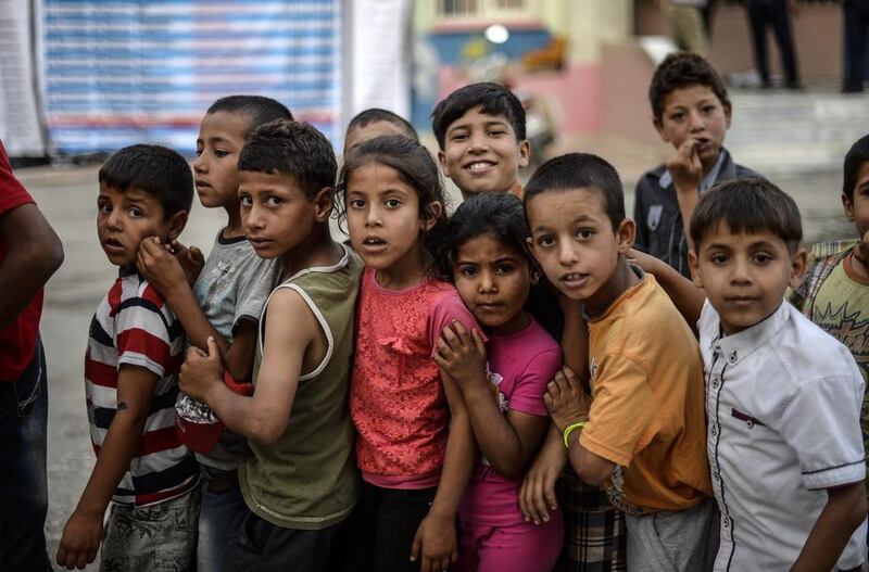 Young Syrian refugee children line up for food as Syrians break their fasting on June 20, 2015 in Akcakale, Turkey, during the holy month of Ramadan. Bulent Kilic / AFP photo