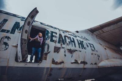 Emirati filmmaker Aiham Al Subaihi looking out of the abandoned plane in Umm Al Quwain. Omar Tartoub 