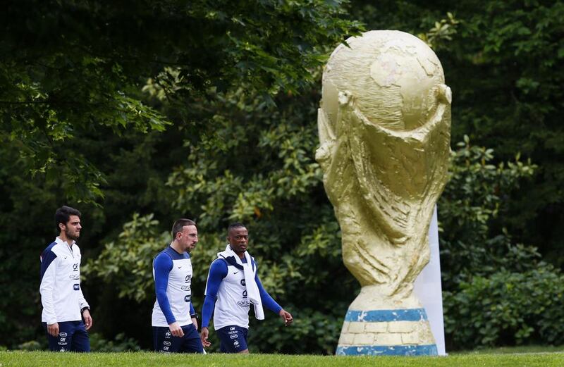 France players Clement Grenier (L), Franck Ribery (2nd L) and Patrice Evra walk beside a World Cup trophy sculpture before a training session in Clairefontaine-en-Yvelines, outside Paris, on May 23, 2014, as part of France's national football team's preparation for the upcoming 2014 World Cup in Brazil. Patrick Kovarik / AFP