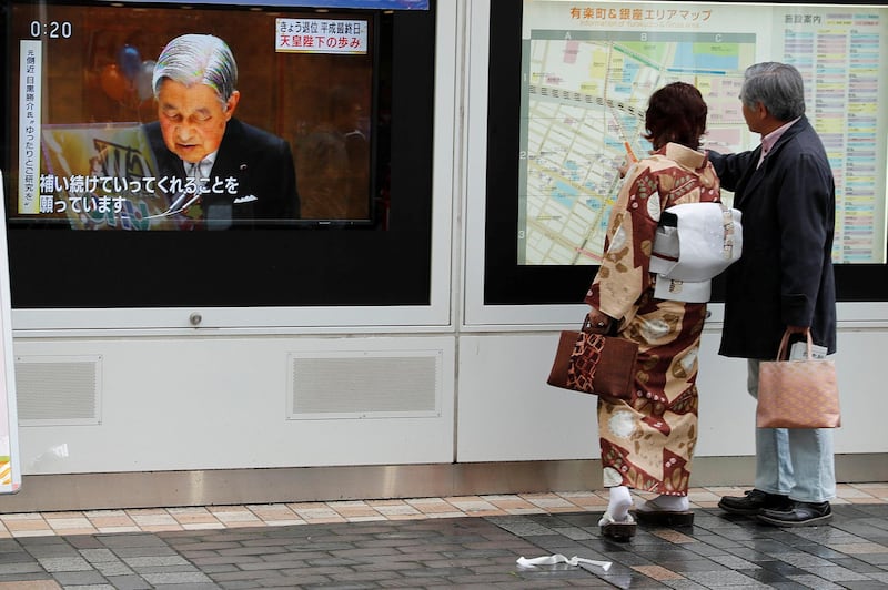 People look at a map next to the screening of a news report on Emperor Akihito in Tokyo, Japan. Reuters