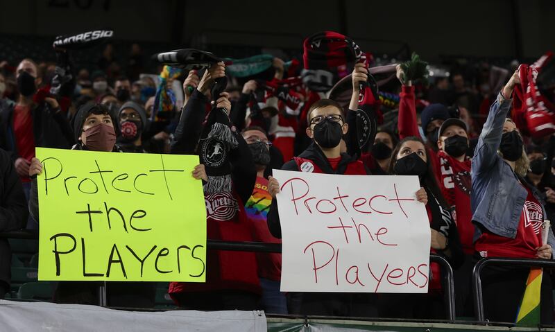 Portland Thorns fans hold signs during the first half of the team's NWSL soccer match against the Houston Dash in Portland, Oregon. Players stopped on the field in the first half of Wednesday night's National Women’s Soccer League games and linked arms in a circle to demonstrate solidarity with two former players who came forward with allegations of sexual harassment and misconduct against a prominent coach.  AP Photo