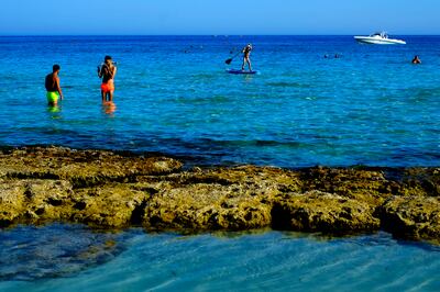 Tourists dip in the sea in Ayia Napa on the Mediterranean island of Cyprus. AP Photo / Petros Karadjias