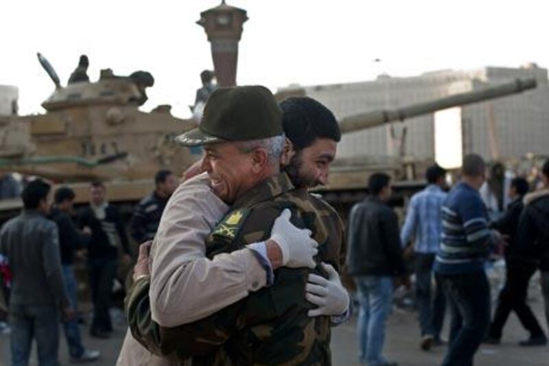 An Egyptian man hugs an army commander at Cairo's Tahrir Square, the epicentre of the popular revolt that drove veteran strongman Hosni Mubarak from power, on February 12, 2011. Thousands of Egyptians were still singing and waving flags as dawn broke over a nation reborn, after a popular uprising toppled Mubarak. AFP PHOTO/PEDRO UGARTE