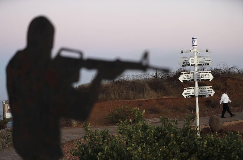 A metalic statue representing an Israeli soldier is pictured near an army post on Mount Bental in the Israeli-annexed Golan Heights, in front of a signpost showing the direction and the distance to Tel Aviv as well as world cities and capitals such as, Tehran, Beijing and Damascus.  AFP