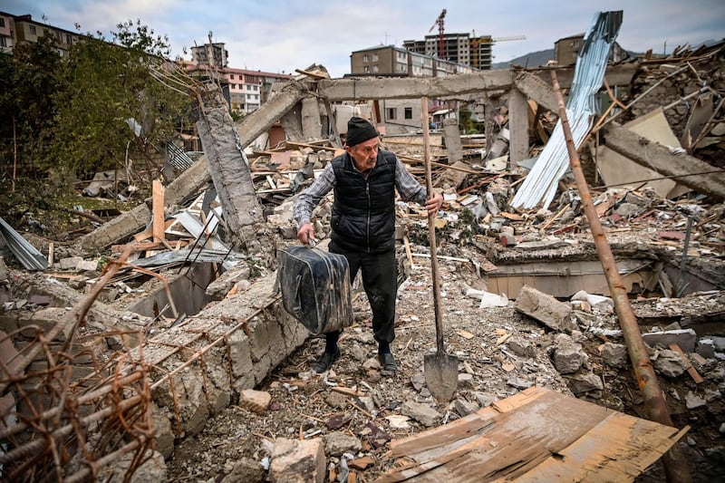 Retired police officer Genadiy Avanesyan, 73, searches for belongings in the remains of his house, which is said was destroyed by Azeri shelling, in the city of Stepanaker.  AFP