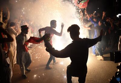 TOPSHOT - Supporters of Pakistan's cricketer-turned politician Imran Khan, and head of the Pakistan Tehreek-e-Insaf (Movement for Justice) party, celebrate in Karachi on July 26, 2018, a day after a general election.

 Pakistan cricket hero turned politician Imran Khan has claimed victory on July 26, in the country's tense general election marred by allegations of "blatant" rigging by rival parties. A visibly tired Khan cut a conciliatory tone in a wide-ranging address to the nation following a controversial contest hit by accusations from major political parties of poll rigging and long delays in still unreleased official results. / AFP / RIZWAN TABASSUM
