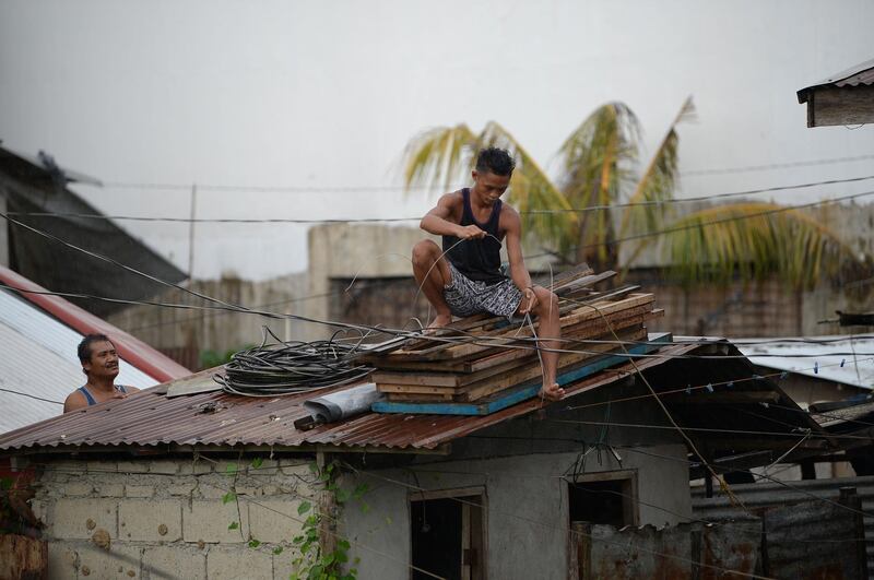 Residents secure the roof of their house as Typhoon Mangkhut approaches the city of Tuguegarao, Cagayan province, north of Manila. Ted Aljibe / AFP