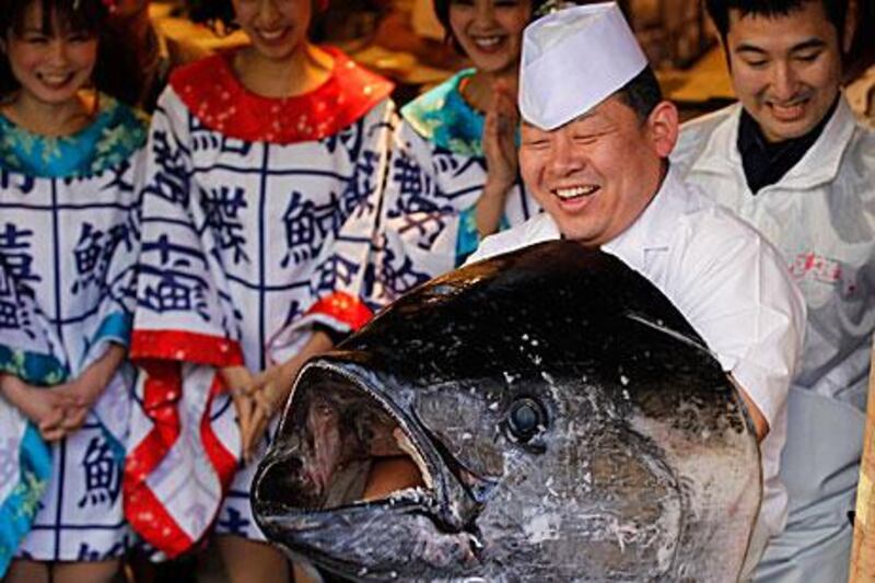 A chef holds a head of a giant bluefin tuna after cutting its meat at a sushi restaurant in Tokyo yesterday. The 269 kilogram fish, caught off the coast of northern Japan, was sold for at a record price of US $736,234 (Dh2.7 million) in the country’s first fish auction of the year.