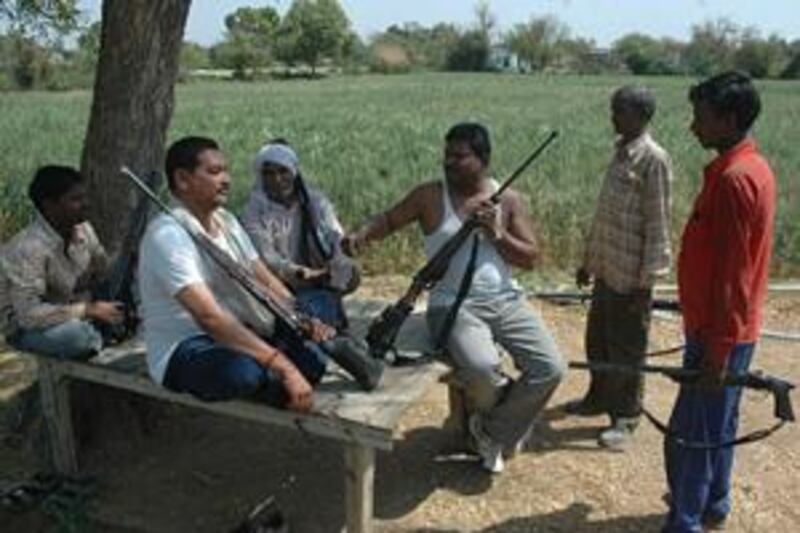 In parts of central India where abduction is high, people carry guns wherever they go. Men in Madhya Pradesh's Gwalior district sit with their weapons.