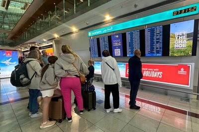 Passengers check flight information on screens at the Dubai International Airport in Dubai on Wednesday. AFP