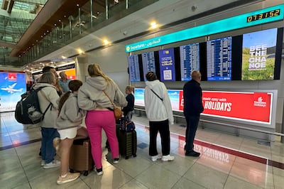 Passengers check flight information on screens at the Dubai International Airport in Dubai on Wednesday. AFP