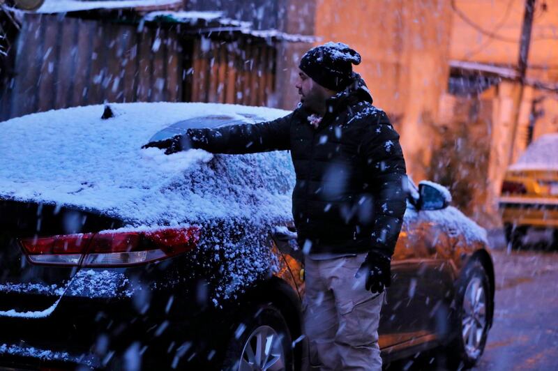 A man cleans the snow off of his car in Baghdad, Iraq. AP Photo