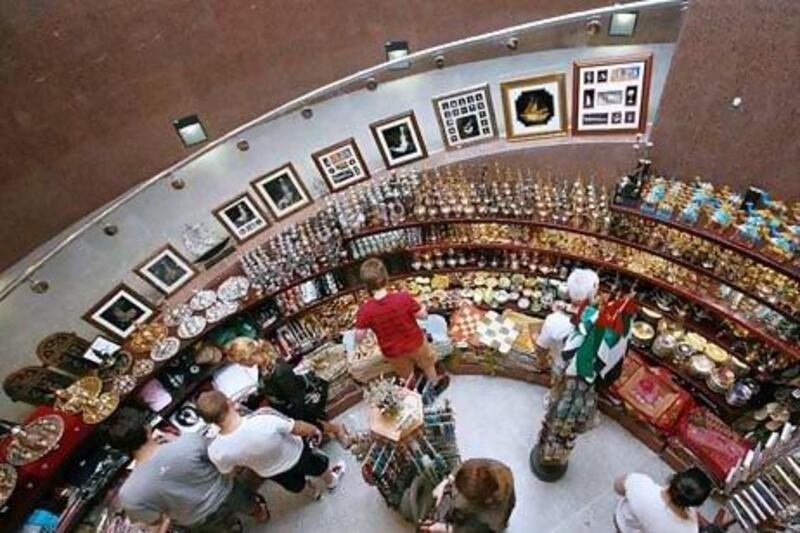 Tourists browse through a souvenir shop in Dubai. Both Dubai and Abu Dhabi are aiming to increase the number of tourists visiting the UAE in the next few years. Jeffrey E Biteng / The National