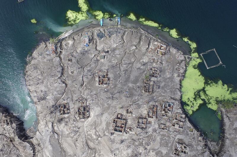 A drone image shows damaged houses among volcanic ash deposits at the Taal volcano in Batangas, Philippines. A year has passed since the Taal volcano erupted, leaving thousands of residents displaced. EPA