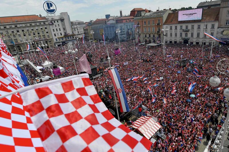 People wave flags as they gather for a 'heroes' welcome' in tribute to the Croatian national football team. Andrej Isakovic / AFP