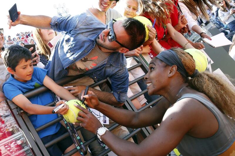 Serena Williams (R) of the US poses for a selfie with a supporter as she signs on a ball, after winning the women’s singles final match against Sara Errani of Italy, at the Rome Masters tennis tournament. Giampiero Sposito / Reuters
