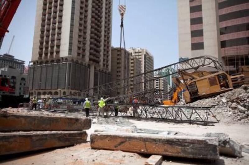 Construction workers work away to clean up remains of a crane that collapsed earlier that morning on Tuesday, July 12, 2011, during the morning rush hour in downtown Abu Dhabi. No one was hurt and only road blocks and the crane itself suffered damages. (Silvia Razgova/The National)

