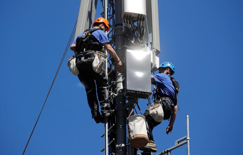 Technicians are roped up as they install 5G antennas of Swiss telecom operator Swisscom on a mast in the mountain resort of Lenzerheide, Switzerland June 13, 2019. REUTERS/Arnd Wiegmann