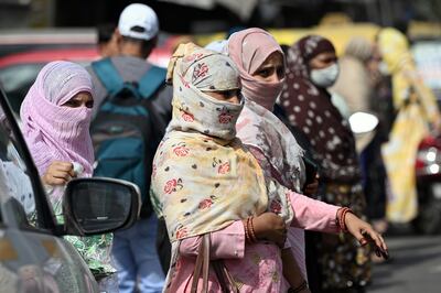 Pedestrians cover their faces to shield from the sun in New Delhi. Bloomberg
