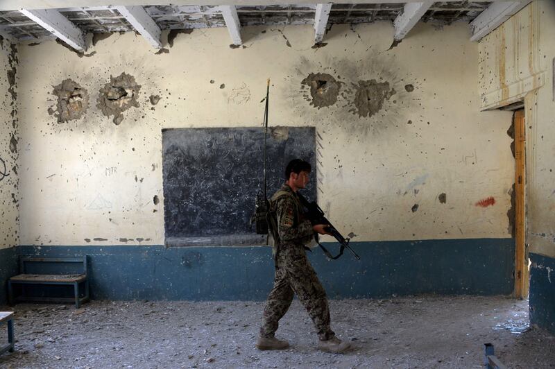 An Afghan security force member patrols inside a school that was used by Islamic State (IS) militants against Afghan forces in Kot District in eastern Nangarhar province. AFP