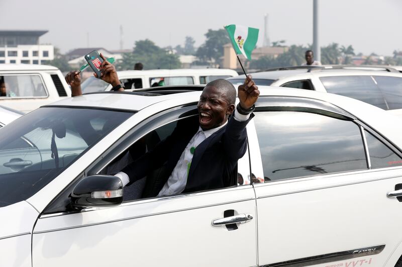 A demonstrator raises a Nigerian flag at the protest in Lagos.  Reuters