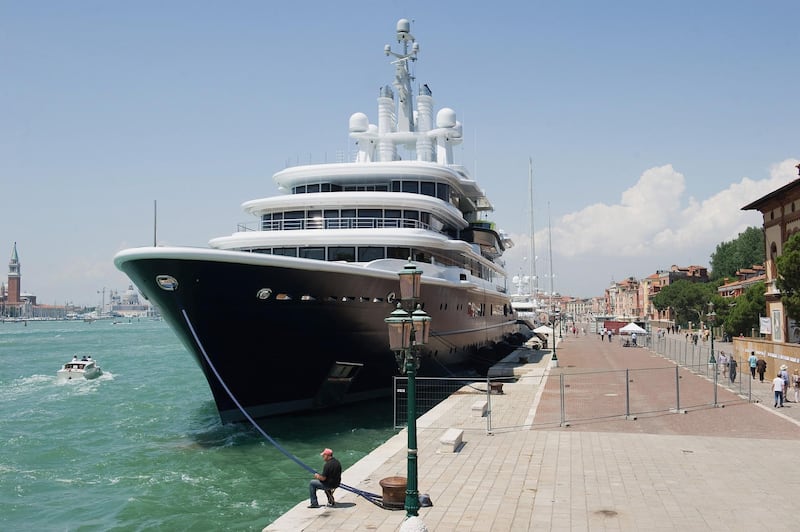 VENICE, ITALY - JUNE 05:  A man attempts to fish in front of the super yacht "Luna" owned by Russian billionaire Roman Abramovich and currently moored in Riva Sette Martiri overlooking St Mark's Basin between the Biennale Gardens and St Mark's Square as people walk around the security barriers surrounding it on June 5, 2011 in Venice, Italy. Most Venetians are against the arrival and mooring of super yachts and Venice Mayor Giorgio Orsoni has suggested imposing an eco-tax to limit the presence of these giant vessels in the basin.  (Photo by Marco Secchi/Getty Images)