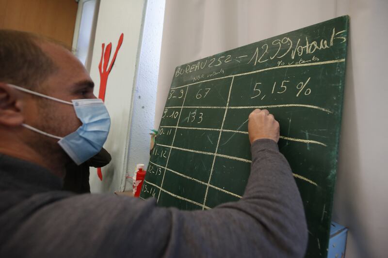 A polling station worker checks voters turnout by hour at a polling station in Marseille. EPA