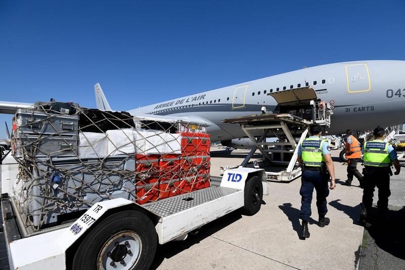 French Gendarmes stand as medical and sanitary supplies are loaded aboard a Airbus A330, at Roissy airport, near Paris. AFP