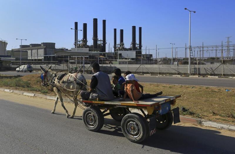 A father and his children ride their donkey cart past the now idle Gaza power plant at Nusseirat, in the central Gaza Strip on June 4, 2017.  Gaza has the longest-ever daily power cuts. Adel Hana / AP 