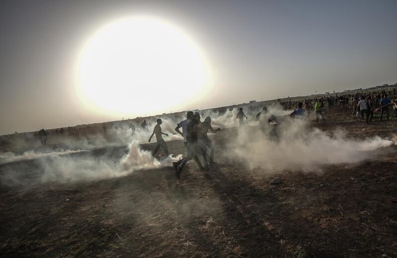 epaselect epa06832315 Palestinians protesters run for cover from Israeli tear-gas during the clashes after a protest near the border in east Gaza City, 22 June 2018. Protesters plan to call for the rights of Palestinian refugees across the Middle East to return to their homes that they fled in the war surrounding the 1948 creation of Israel.  EPA/MOHAMMED SABER