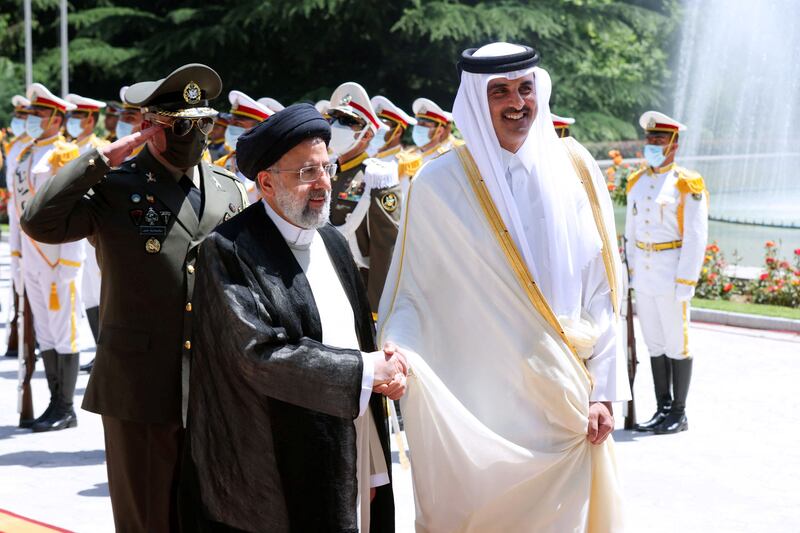 Mr Raisi shakes hands with Qatari Emir Sheikh Tamim bin Hamad al-Thani during a welcoming ceremony in Tehran, on May 12, 2022. Reuters