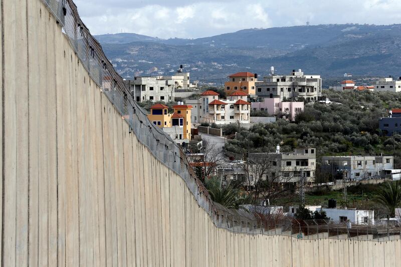 Buildings in the Palestinian village of Nazlat Isa near Tulkarm in the Israeli-occupied West Bank are seen behind the Israeli barrier and from the Arab-Israeli village of Baqa al-Gharbiyye on February 1, 2020. Reuters