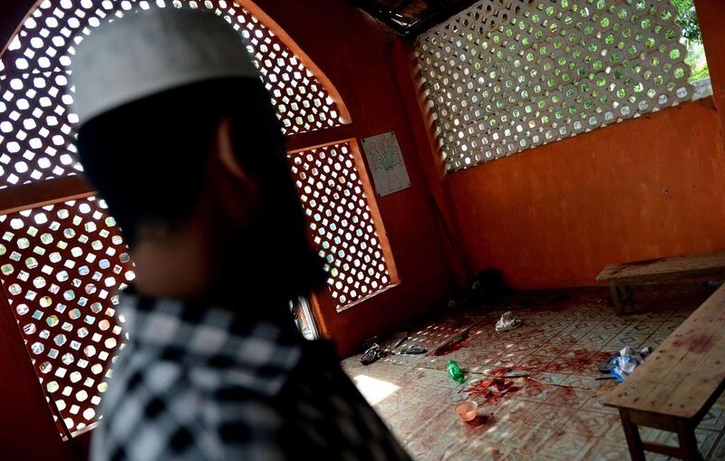 A Muslim resident in the town of Alutgama looks at a pool of blood and discarded belongings inside a mosque following clashes between Muslims and an extremist Buddhist group. AFP PHOTO / Ishara S. KODIKARA

