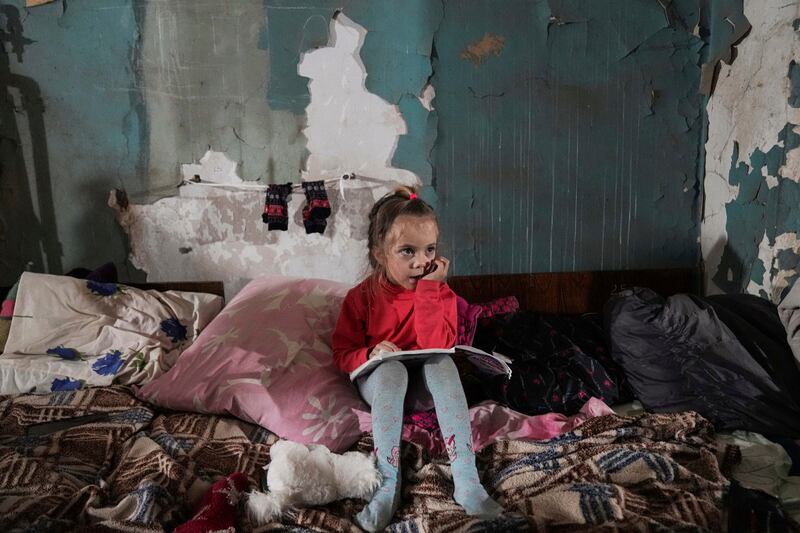 A girl sits in an improvised bomb shelter in Mariupol, Ukraine. AP