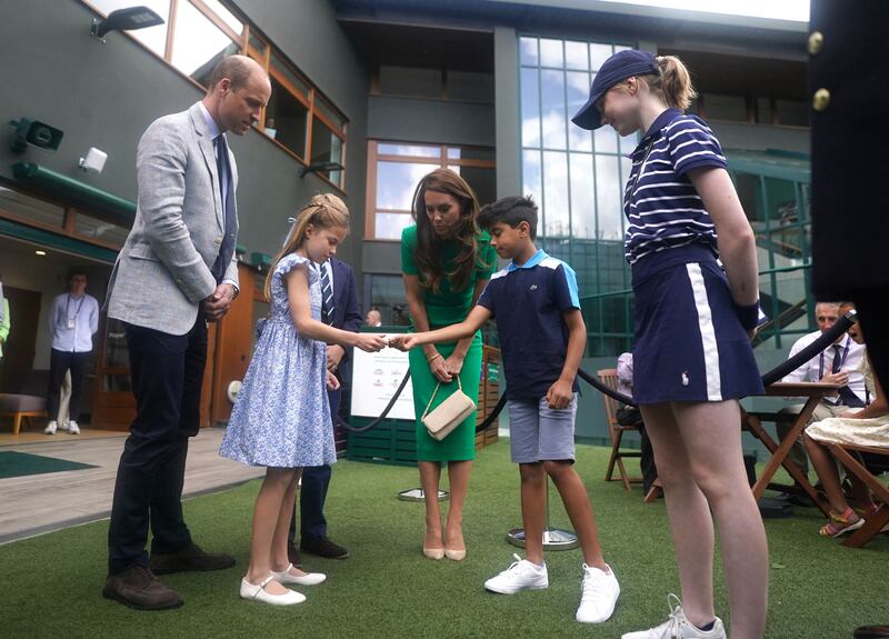 The Duke and Duchess of Cambridge watch as Princess Charlotte  and Prince George speak to Mu'awwiz Anwar, who will toss the coin for men's singles final. AFP