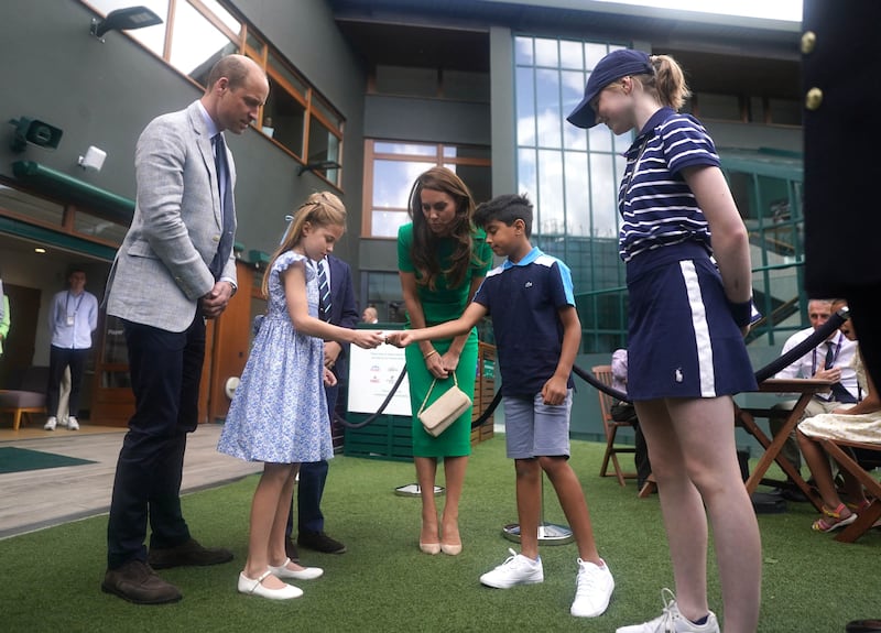 The Duke and Duchess of Cambridge watch as Princess Charlotte  and Prince George speak to Mu'awwiz Anwar, who will toss the coin for men's singles final. AFP