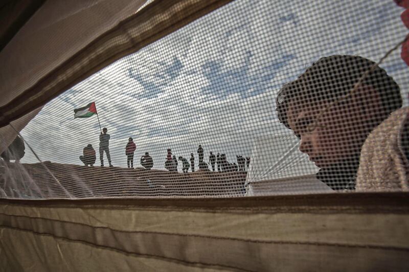 A Palestinian child stands outside a tent during a protest near Khan Younis in the southern Gaza Strip on March 30, 2018, which is observed as Land Day to mark the killing of six Arab Israelis during 1976 demonstrations against Israeli confiscations of Arab land. Said Khatib / AFP