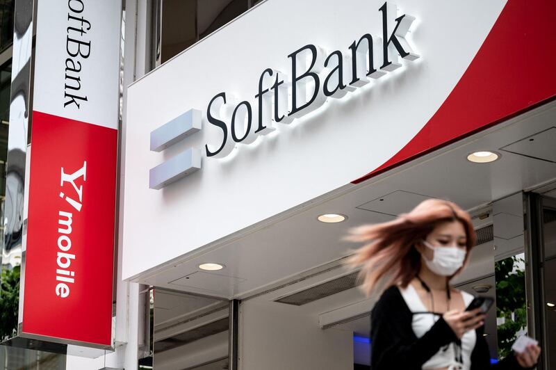 A woman walks past a logo of the SoftBank Group in Tokyo on May 12, 2021. / AFP / Philip FONG
