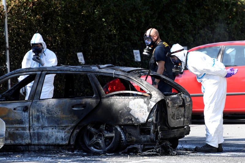 Police examine a burnt-out car in Malmo, Sweden, where politicians have called for tough action against gangland violence. Reuters