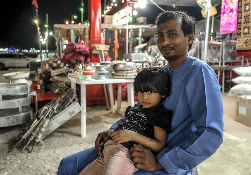 Abu Dhabi, United Arab Emirates, December 10, 2019.  
  --Akhbar Hussein with his daughter, Muntaha,5, tends Al Mansoori Supply general store on Millions Street at Al Dhafra Festival.
Victor Besa/The National
Section:  NA
Reporter:  Anna Zacharias