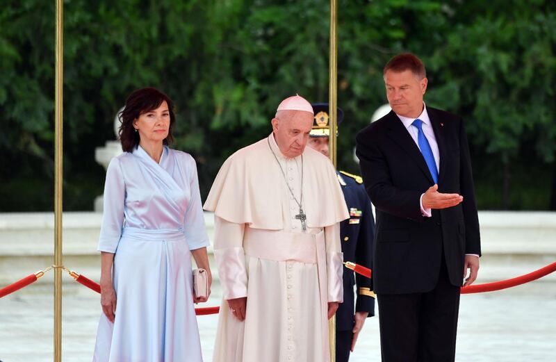 Romania's President Klaus Iohannis (R), his wife Carmen Iohannis (L) and Pope Francis (C) inspect an honor guard at the Presidential Palace in Bucharest on May 31, 2019. Pope Francis is heading to Romania with a message of integration not just for its faith communities but for a post-election European Union, following nationalist gains. During the three-day trip to the mainly Orthodox country, which sits at the crossroads of Western and Eastern Europe, Francis is expected to touch on issues fuelling nationalism, such as poverty, as well as inter-religious relations.
 / AFP / Daniel MIHAILESCU
