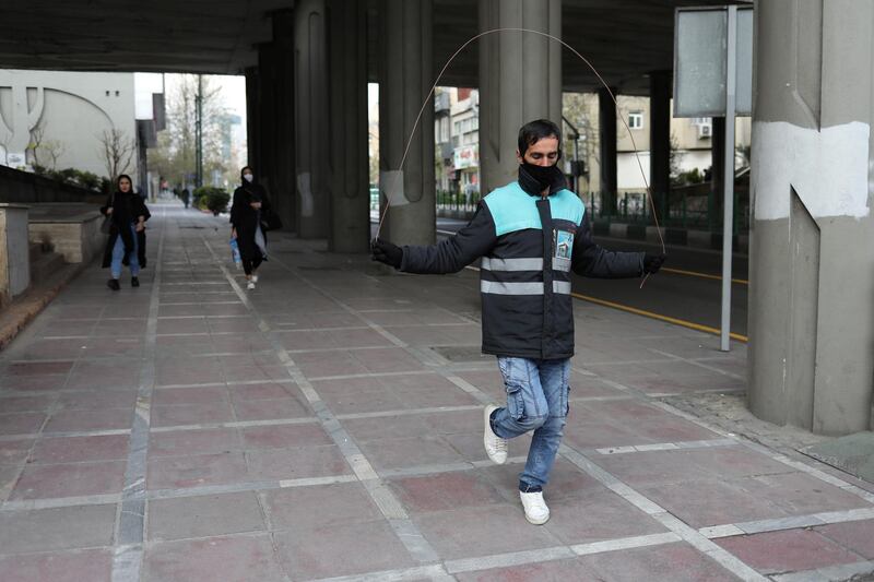 A man wearing a protective face mask and gloves, amid fear of coronavirus disease (COVID-19), jumps rope at Valiasr street in Tehran, Iran.  REUTERS