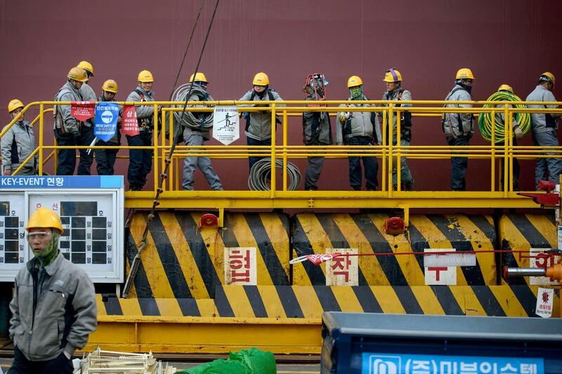 Workers queue to enter an under-construction Maersk triple-E class container ship. Ed Jones / AFP