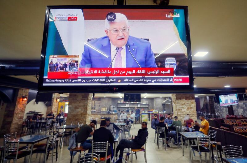 A screen displaying a live broadcast of Palestinian President Mahmoud Abbas's speech during a meeting to discuss upcoming elections, is seen in a coffee shop in Ramallah in the Israeli-occupied West Bank April 29, 2021. REUTERS/Mohamad Torokman