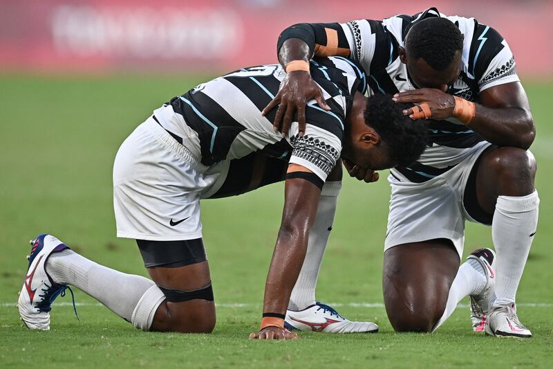 Fiji's Napolioni Bolaca (L) reacts with a teammate after winning the men's rugby sevens match against New Zealand at the Tokyo Stadium.