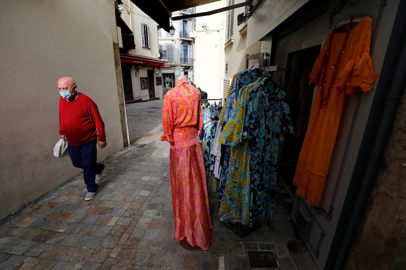 A man walks past a clothing store during the lockdown in Cannes. EPA