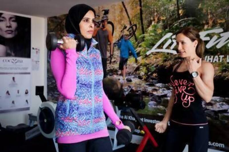 Both the personal trainer Derryn Brown, right, and her client Asma Lootah are wearing Lorna Jane workout clothes, which they say help women feel confident. Razan Alzayani / The National